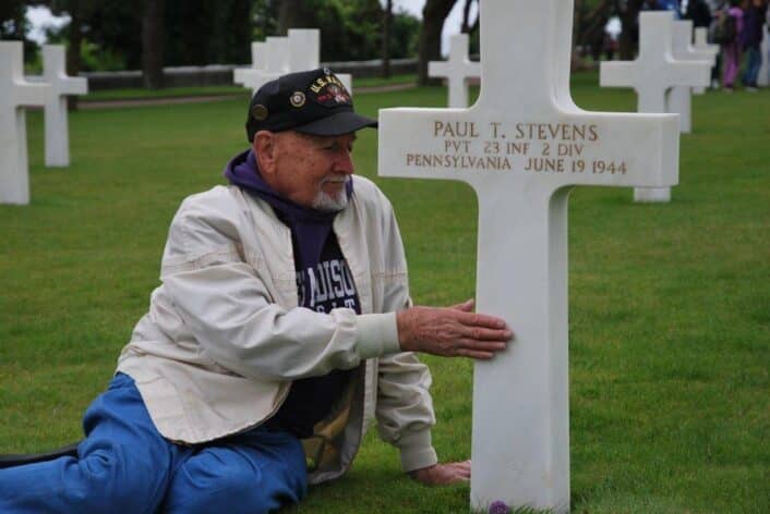Donald Stevens sur la tombe de son frère Paul, au cimetière américain de Colleville-sur-Mer